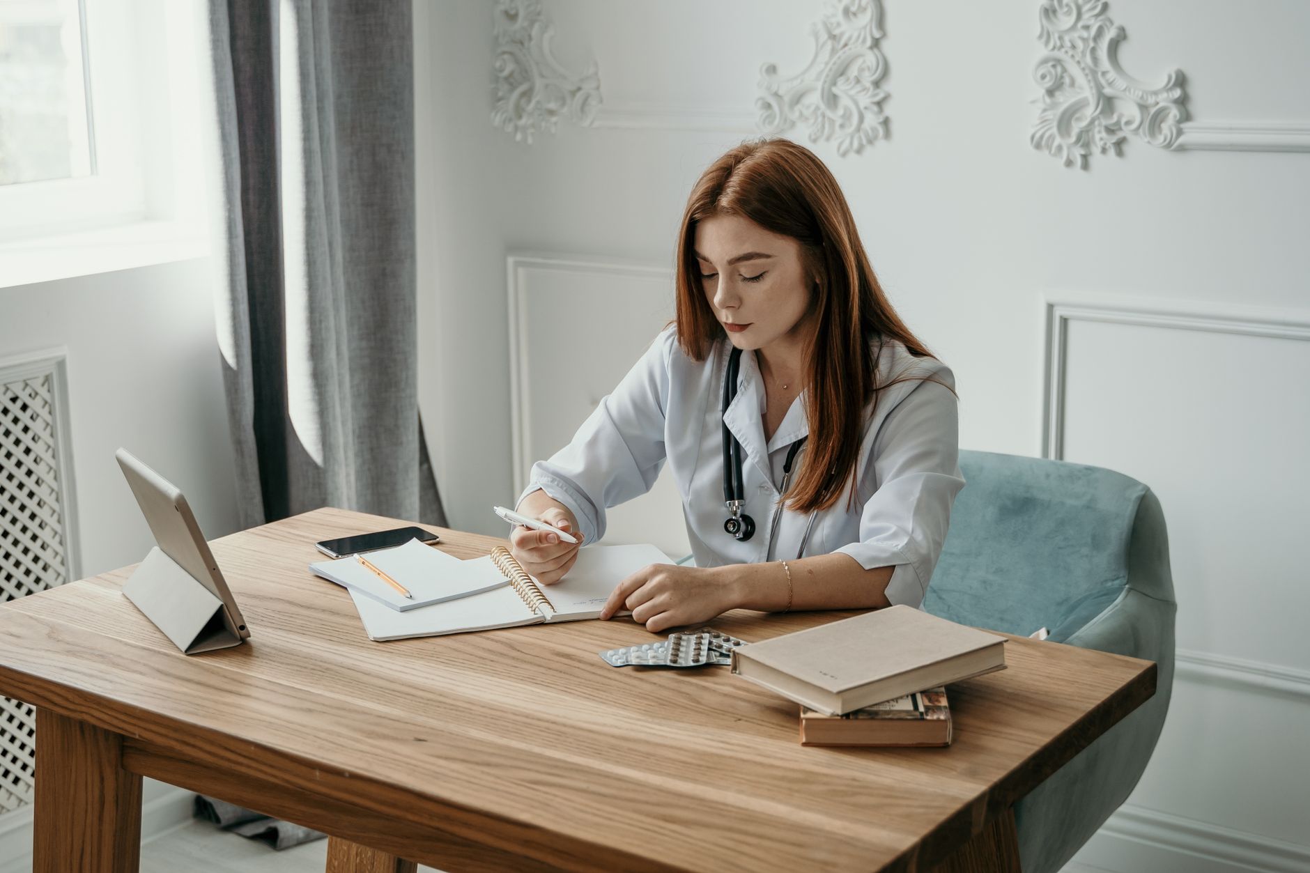 Carnet cu notițe și stetoscop pe un birou, pregătite pentru o consultație medicală
