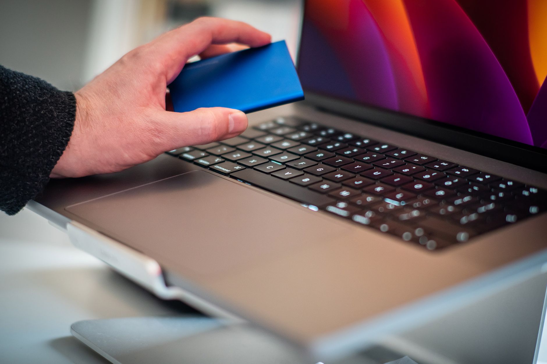 Hard disk extern conectat la un laptop pe un birou, folosit pentru copia de siguranță a fișierelor